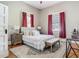 Bright main bedroom with red curtains, a plush rug, a neutral color scheme, and wood flooring at 141 S Central Ave, Apopka, FL 32703