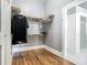 Walk-in closet with shelving, storage, hardwood floors, and a door to the bathroom with glass-enclosed shower at 141 S Central Ave, Apopka, FL 32703
