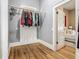 Bright closet with wood flooring features a clothes bar for hanging garments, with the Primary bedroom adjacent at 141 S Central Ave, Apopka, FL 32703