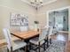 Traditional dining room features hardwood floors, modern chandelier, and a rustic wooden table with seating for six at 141 S Central Ave, Apopka, FL 32703