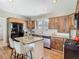 Charming kitchen with granite countertops, stainless steel appliances, breakfast bar, and beautiful natural wood cabinetry at 141 S Central Ave, Apopka, FL 32703