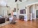 Bright living room with elegant hardwood floors, a cozy fireplace, and access to the staircase at 141 S Central Ave, Apopka, FL 32703
