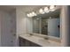 Bathroom features dual sinks, a large mirror with vanity lighting, and a glass-enclosed shower at 1429 Discovery St, Davenport, FL 33896