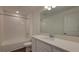 Bathroom with a combined tub and shower, complemented by white cabinetry and granite countertops at 1429 Discovery St, Davenport, FL 33896