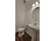 Half bathroom with pedestal sink, wood-look floors, and updated lighting fixtures at 1429 Discovery St, Davenport, FL 33896