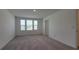 Bright bedroom featuring three windows providing natural light and plush carpeting at 1429 Discovery St, Davenport, FL 33896