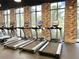 The on-site fitness center has new treadmills, offering a modern workout experience with brick accent walls at 1429 Discovery St, Davenport, FL 33896