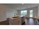 Kitchen island features stainless dishwasher, sink, white cabinets, and wood-look floors; great for entertaining at 1429 Discovery St, Davenport, FL 33896