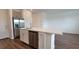 Kitchen island is equipped with a stainless dishwasher, sink, white cabinets, and wood-look flooring at 1429 Discovery St, Davenport, FL 33896