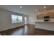 Open-concept floor plan boasts a spacious kitchen with gray cabinetry, stainless appliances, and wood-look flooring at 1429 Discovery St, Davenport, FL 33896