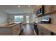 Modern kitchen has an island, stainless appliances, gray cabinets, pendant lights, and wood-look floors at 1429 Discovery St, Davenport, FL 33896