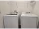 Laundry room featuring a front-load washer and dryer with overhead shelving for storage at 1429 Discovery St, Davenport, FL 33896
