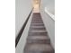 Carpeted staircase with a wooden banister and white trim leading to the upper level at 1429 Discovery St, Davenport, FL 33896