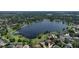 Stunning aerial view showcases the lakefront community with lush greenery and beautiful homes at 208 Frinton Cv, Longwood, FL 32779