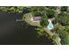 Aerial view of waterfront home with dock, swimming pool, and manicured yard at 208 Frinton Cv, Longwood, FL 32779