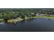 Aerial view of a lakefront property with a gazebo, dock, and tennis courts at 208 Frinton Cv, Longwood, FL 32779