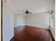 Bedroom featuring hardwood floors, closet, ceiling fan and window overlooking yard at 208 Frinton Cv, Longwood, FL 32779