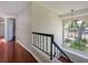 Hallway with hardwood floors, a large arched window and a black wrought iron railing at 208 Frinton Cv, Longwood, FL 32779