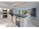 Updated kitchen with stainless steel appliances, modern countertops, custom cabinets, and marble tile flooring at 208 Frinton Cv, Longwood, FL 32779