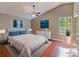 Staged main bedroom with vaulted ceiling, hardwood floors, large windows, and stylish decor at 208 Frinton Cv, Longwood, FL 32779
