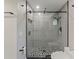 Updated shower featuring gray tile, mosaic tile floor, black trim and seamless glass door at 208 Frinton Cv, Longwood, FL 32779