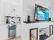 Built-in wet bar with a wine refrigerator next to the fireplace with stacked stone and a large screen TV at 2108 Antilles Club Dr, Kissimmee, FL 34747