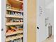 Organized pantry with pull-out wooden shelves for easy access to food items and essentials at 2108 Antilles Club Dr, Kissimmee, FL 34747