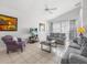 Bright living room featuring neutral colors, tiled floors, ceiling fan, and large windows at 2115 Morning Star Drive, Clermont, FL 34714