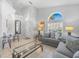 Bright living room featuring neutral paint, tile floors, and a large arched window for natural light at 2115 Morning Star Drive, Clermont, FL 34714