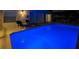 Inviting swimming pool with bright blue lighting and lounge chairs at 2115 Morning Star Drive, Clermont, FL 34714