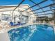 Inviting screened-in pool and spa area with outdoor furniture for lounging and dining at 2115 Morning Star Drive, Clermont, FL 34714