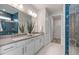 Contemporary bathroom with double sinks, decorative tile in shower, and a separate toilet and walk-in closet at 2333 Daisy Tree Rd, St Cloud, FL 34771