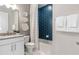 Stylish bathroom featuring modern vanity, commode, and blue accent tile in the shower at 2333 Daisy Tree Rd, St Cloud, FL 34771