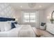 Comfortable bedroom with a blue headboard, patterned wallpaper, and a view of the lake through the bright window at 2333 Daisy Tree Rd, St Cloud, FL 34771