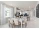 Dining area with a white table and chairs, adjacent to a modern kitchen with stainless steel appliances and bar seating at 2333 Daisy Tree Rd, St Cloud, FL 34771