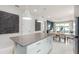 Open concept kitchen featuring a large island, modern pendant lighting, and a view into the dining area at 2333 Daisy Tree Rd, St Cloud, FL 34771