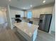 Modern kitchen featuring white cabinets, stainless steel appliances, and a large center island at 2333 Daisy Tree Rd, St Cloud, FL 34771