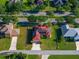 An aerial shot showcases a home with solar panels on a lush green lawn, bordered by manicured landscaping and mature trees at 3174 Grasmere View Pkwy, Kissimmee, FL 34746