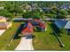 An aerial shot showcases a home with solar panels and a lush green lawn, surrounded by well-maintained landscaping at 3174 Grasmere View Pkwy, Kissimmee, FL 34746