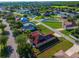 Aerial view showcasing homes in a residential area, highlighting one with solar panels set in a lush green lawn at 3174 Grasmere View Pkwy, Kissimmee, FL 34746
