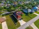Aerial view of a home with solar panels on the roof, situated on a well-maintained lawn with a driveway and landscaping at 3174 Grasmere View Pkwy, Kissimmee, FL 34746