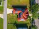 Aerial view of house featuring solar panels, a red roof and green lawn plus nearby pool at 3174 Grasmere View Pkwy, Kissimmee, FL 34746