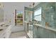 The spa-like bathroom features luxurious tile, a glass shower, and double vanities with gold fixtures at 3174 Grasmere View Pkwy, Kissimmee, FL 34746
