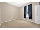 This bedroom has neutral walls, carpet, and a window with dark curtains at 3174 Grasmere View Pkwy, Kissimmee, FL 34746