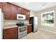 Cozy kitchen featuring stainless steel appliances and warm wood cabinetry at 3174 Grasmere View Pkwy, Kissimmee, FL 34746