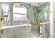 The large glass shower features gold fixtures, built-in seating, and a mosaic tile floor at 3174 Grasmere View Pkwy, Kissimmee, FL 34746