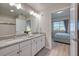 Well-lit bathroom with double vanity, granite countertops, and a view into the bedroom at 4013 Breakview Dr # A407, Orlando, FL 32819