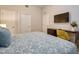 Bright bedroom featuring a bed with blue patterned bedding, desk area, and mounted TV at 4013 Breakview Dr # A407, Orlando, FL 32819