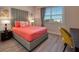 Bright bedroom with a modern gray headboard and stylish coral-colored bedding, desk, and window views at 4013 Breakview Dr # A407, Orlando, FL 32819