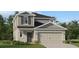 Charming two-story home showcasing a gray color scheme, attached two-car garage, and professionally landscaped yard at 4082 Old Mill Rd, Haines City, FL 33844